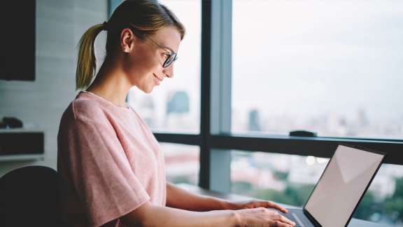 Female individual working on a laptop in a remote setting