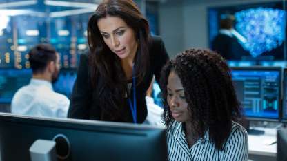 Female team leader mentoring an young computer engineer